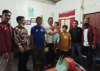 Parlindungan Purba (Kenakan kemeja putih) menggendong Yolanda. (Foto : Jonli Simarmata)