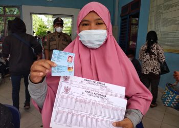 Salah seorang warga menunjukkan dokumen kependudukannya, yang baru diterbitkan oleh Disdukcapil Kabupaten Simalungun. (Foto: Wahanainfo.com)