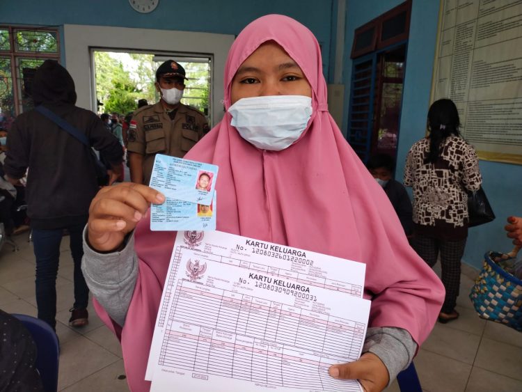 Salah seorang warga menunjukkan dokumen kependudukannya, yang baru diterbitkan oleh Disdukcapil Kabupaten Simalungun. (Foto: Wahanainfo.com)