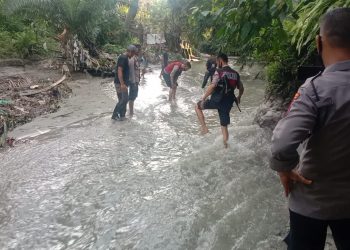 Personel Polres Simalungun melakukan penyusuran di aliran Sungai Bah Bolon, untuk mencari petunjuk, sehubungan dengan penemuan potongan kaki manusia di sekitar lokasi serupa. (Foto: Wahanainfo.com)